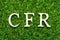 Wood letter in word CFR abbreviation Cost and freight on green grass background