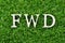 Wood letter in word FWD Abbreviation of forward on green grass background