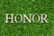 Wood letter in word honor on green grass background