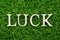 Wood letter in word luck on artificial green grass background