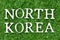 Wood letter in word north korea on green grass background