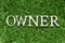 Wood letter in word owner on artificial green grass background
