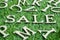 Wood letter in word sale on artificial green grass with English alphabet background