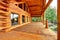 Wood log cabinet porch with entrance and bench.