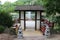 A wood pagoda leading to a viewing platform and seating area over a lake with a water fountain in Janesville, Wisconsin