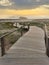 A wood pedestrian walkways, build over a sand dune that is used to give beach access in Furadouro beach, glows at sunset. Ovar,