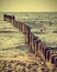 Wood pilings on beach, vintage retro instagram effect.