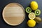 Wood plate with kiwi and lemon. Top view, flat lay