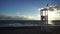 wood rescue observation post and sand beach with azure stormy sea, cloudy sky background. Empty beach with sunshades