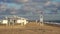 wood rescue observation post and sunshades and sand beach with azure sea, cloudy sky background. Empty beach with