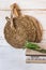 Wood round cutting board, rattan coaster, stack of linen kitchen towels, rosemary twigs on white plank wood