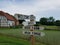 Wood sign saying America, welcome center, and Irish farm, with building and grass field