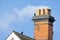 Wood smoke billowing from chimney of old UK house