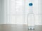 Wood table with bottle of water on blurry beautiful white drape