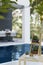 Wood table with cactus shelf and a cup of coffee over blurred background of swimming pool