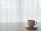 wood table with coffee cup on beautiful white drape window texture background.