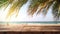 wood table with seascape and palm leaves, blur bokeh light of calm sea and sky at tropical beach background