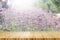 Wood table top on blur background of blooming Verbena field on summer sunset - can be used for display or montage your products