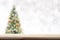 Wood table top on blur Christmas tree background in snowfall