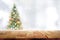 Wood table top on blur Christmas tree in snowfall background