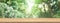 Wood table top and blur green forest for product and display montage banner size.