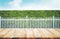 Wood table top on blur of white fence and garden background.