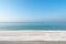 Wood table top on blurred blue sea and white sand beach background