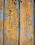 Wood texture with yellow flaked paint. Peeling paint on weathered wood