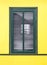 Wood window color green with white shutters on yellow colored wa