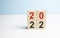 woodblocks cubes with a number 2021 change to 2022 blue background. new year 2021- 2022 concept