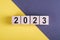 Woodblocks cubes square with number 2023 on yellow and gray background. Business goals next year. New year 2023 concept