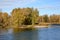 Wooded riverbank in autumn with trees in fall colors