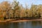 Wooded riverbank in autumn with trees in fall colors