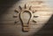 Wooden 3d lightbulb lamp innovation creativity energy symbol with spotlight