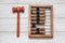 Wooden abacus with judge gavel for sentencing on white background.