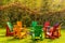 Wooden adirondack chairs arranged in a circle around a fire pit