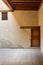 Wooden aged door and window covered with wooden grid on grunge stone wall and wood timber ceiling