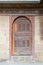 Wooden aged vaulted door and stone wall