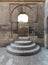 Wooden aged vaulted open door, three steps and stone wall