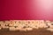 Wooden alphabet blocks with DYSLEXIA word in the center on wooden table against pink background