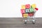 Wooden Alphabet Blocks with shopping cart trolley on wood table