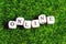 Wooden alphabet in online wording on the background of artificial green grass.