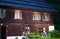 Wooden Alpine lodge with flower pots on the front lawn