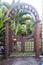 Wooden arbor with close gate in garden. Wooden arched entrance to the backyard.