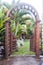 Wooden arbor with gate in garden. Wooden arched entrance to the backyard.