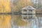 Wooden arbour in autumn by a lake with reflections