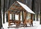 Wooden arbour covered with white snow in the forest