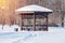 Wooden arbour in the snow-covered park