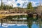 Wooden arch footbridge in Cascade Ponds park in autumn sunny day. Banff National Park, Canadian Rockies.