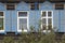 Wooden architecture of Siberia, old Windows with wooden carved architraves. old peeling paint on the wooden Windows